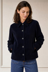 Model wearing the Aspiga Corduroy Collared Jacket in Deep Navy with jeans, hands in pockets, front view on plain background