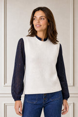Model wearing the Aspiga Merino Wool Knitted Short Tank in Ivory layered over a navy lace blouse with dark denim, full-length front view