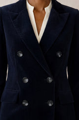 Model wearing the Aspiga Double Breasted Corduroy Blazer in Deep Navy, a tailored corduroy blazer with a peak lapel and double-breasted button front, alternate view