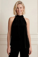 Model wearing the Aspiga Velvet Halter Top in Black, front view, smiling