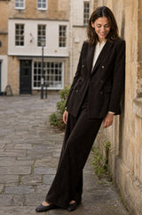 Model wearing the Aspiga Double Breasted Corduroy Blazer in Chocolate Brown, a tailored corduroy blazer with a peak lapel and double-breasted button front, alternate view