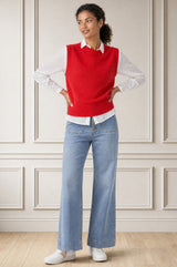 Model wearing the Aspiga Merino Wool Knitted Short Tank in Red, a ribbed knit crew-neck sweater vest layered over a white collared blouse, alternate view