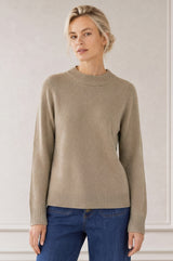 Model wearing the Aspiga Merino Wool Crew Neck Jumper in Oatmeal with navy corduroy trousers, hands in pockets, full-length front view