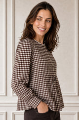 Close-up side profile of a smiling model wearing the Aspiga Mina Gingham Check Blouse in Chocolate/White