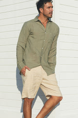 a man wearing a green linen khaki shirt with beige linen shorts