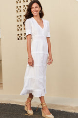 White midi dress with lace trim around the short sleeve, v neckline lace waistband and raw edge frill details. Styles with gold espadrilles