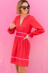 Short red Purdie Dress red with V neckline with pink ric rac detailing around the frill cuffs and waistband