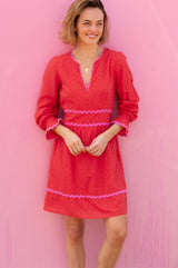 Short red Purdie Dress red with V neckline with pink ric rac detailing around the frill cuffs and waistband