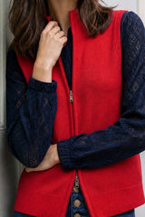 Close-up of a model wearing the Aspiga Merino Wool Zip Through Gilet in Red, hand at collar