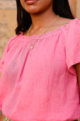 Zoom in of the Ilana pink cotton top with elasticated neckline and hemline styled with Aspiga accessories