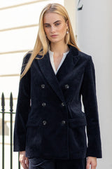 Close-up of a model wearing the Aspiga Double Breasted Corduroy Blazer in Deep Navy over a white blouse