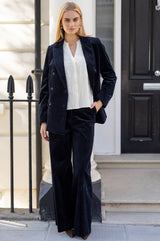 Model wearing the Aspiga Double Breasted Corduroy Blazer in Deep Navy with matching trousers and a white blouse, full-length front view