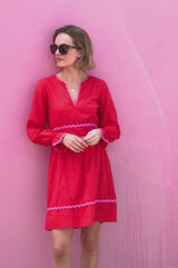Video Short red Purdie Dress red with V neckline with pink ric rac detailing around the frill cuffs and waistband styled with sunglasses
