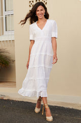 White midi dress with lace trim around the short sleeve, v neckline lace waistband and raw edge frill details. Styles with gold espadrilles