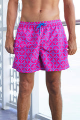 Close-up of a man wearing bright pink and blue patterned swim shorts with a drawstring waist.