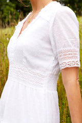 Zoom in of white midi dress with lace trim around the short sleeve