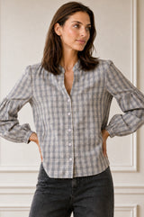 Model wearing the Aspiga Notch Neck Check Blouse in Grey/White with a notch neckline and puff sleeves, hands on hips