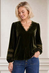 Model wearing the Aspiga Claudette Velvet Blouse in Dark Olive, a velvet blouse with a scalloped lace-trimmed V-neck and puff sleeves, front view