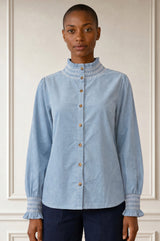 Model wearing the Aspiga Embroidered Smocked Baby Cord Blouse in Ice Blue, buttoned with smocked embroidered collar, front view