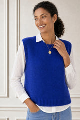 Model wearing the Aspiga Alpaca Blend Knitted Short Tank in Cobalt, a ribbed knit sweater vest layered over a white blouse, front view