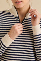 Model wearing the Aspiga Merino Wool Stripe Quarter Zip Jumper in Off White/Navy, a breton-striped quarter-zip jumper, alternate view