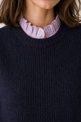Model wearing the Aspiga Alpaca Blend Knitted Short Tank in Navy, a ribbed knit sweater vest layered over a striped blouse, alternate view