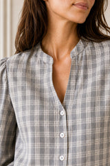 Close-up of the notch neckline and button detail of the Aspiga Notch Neck Check Blouse in Grey/White