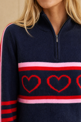 Close-up of the heart motif stripe and zip detail of the Aspiga Merino Wool Stripe Hearts Quarter Zip in Navy/Red/Light Pink