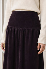 Close-up of the gathered waistband detail of the Aspiga Dropped Waist Baby Cord Skirt in Aubergine