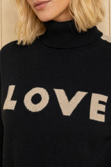 Close-up of the 'LOVE' knitted lettering on the Aspiga Merino Wool Love Polo Neck Jumper in Black/Taupe
