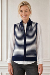 Model wearing the Aspiga Merino Wool Stripe Zip Through Gilet in Navy/Off White over a white blouse with black trousers, front view