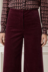 Model wearing the Aspiga Wide Leg Stretch Corduroy Trouser in Burgundy, a high-waisted wide-leg velvet corduroy trouser, alternate view