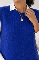 Model wearing the Aspiga Alpaca Blend Knitted Short Tank in Cobalt, a ribbed knit sweater vest layered over a white blouse, alternate view