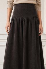 Close-up of the gathered waistband detail of the Aspiga Dropped Waist Baby Cord Skirt in Chocolate