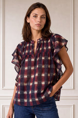 Model wearing the Aspiga Danee Ikat Blouse in Wine, a check-print blouse with ruffle sleeves and V-neck, with jeans, front view