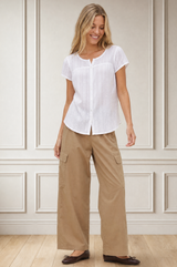 Model wearing the Aspiga Matcha Trousers in Camel with a white lace blouse, full-length front view