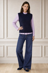 Model wearing the Aspiga Alpaca Blend Knitted Short Tank in Navy, a ribbed knit sweater vest layered over a striped blouse, alternate view