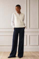 Model wearing the Aspiga Merino Wool V Neck Tank in Ivory, a fine-knit v-neck tank layered over a blouse, alternate view