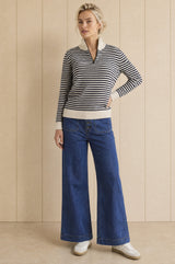 Model wearing the Aspiga Merino Wool Stripe Quarter Zip Jumper in Off White/Navy, a breton-striped quarter-zip jumper, alternate view