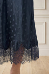 Close-up of the lace hem detail of the Aspiga Satin Jacquard Spot Slip Skirt in Navy