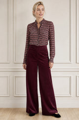 Model wearing the Aspiga Wide Leg Stretch Corduroy Trouser in Burgundy, a high-waisted wide-leg velvet corduroy trouser, alternate view