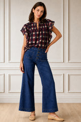 Model wearing the Aspiga Danee Ikat Blouse in Wine with jeans, full-length front view, hand on hip