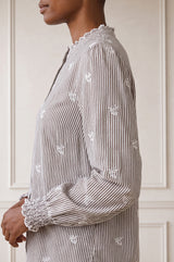 Close-up side profile of the ruffled collar of the Aspiga Cosima Embroidered Blouse in Chocolate/White