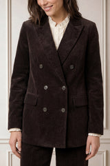 Model wearing the Aspiga Double Breasted Corduroy Blazer in Chocolate Brown, a tailored corduroy blazer with a peak lapel and double-breasted button front, alternate view