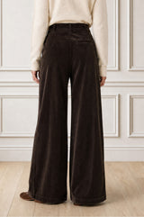 Model wearing the Aspiga Wide Leg Chunky Corduroy Trouser in Chocolate Brown with a cream jumper, back view