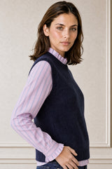 Model wearing the Aspiga Alpaca Blend Knitted Short Tank in Navy, a ribbed knit sweater vest layered over a striped blouse, alternate view