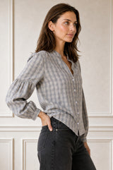 Close-up side profile of a model wearing the Aspiga Notch Neck Check Blouse in Grey/White