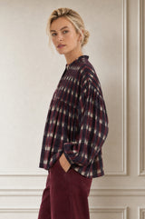 Close-up side profile of a model wearing the Aspiga Mine Ikat Blouse in Wine, hand in pocket