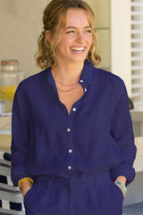 Woman wearing a navy linen collared shirt styled with navy linen shorts