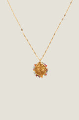 Product photo of a gold necklace with a palm tree motif pendant surrounded by multicolour beads